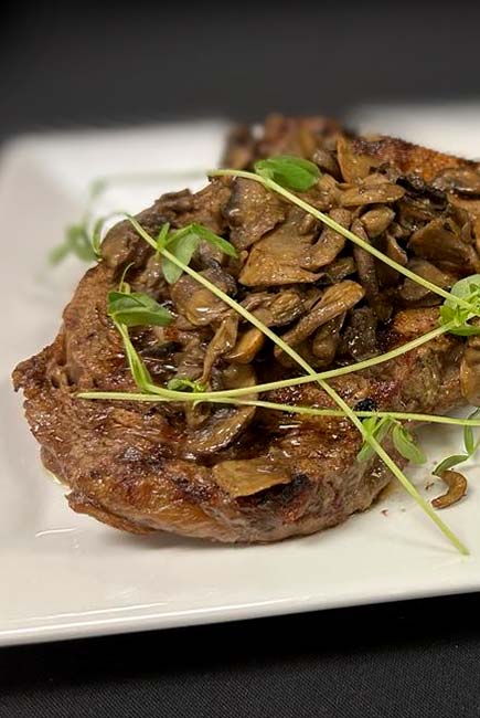 Grilled steak with sautéed mushrooms, served at River’s Edge Supper Club in Marinette.