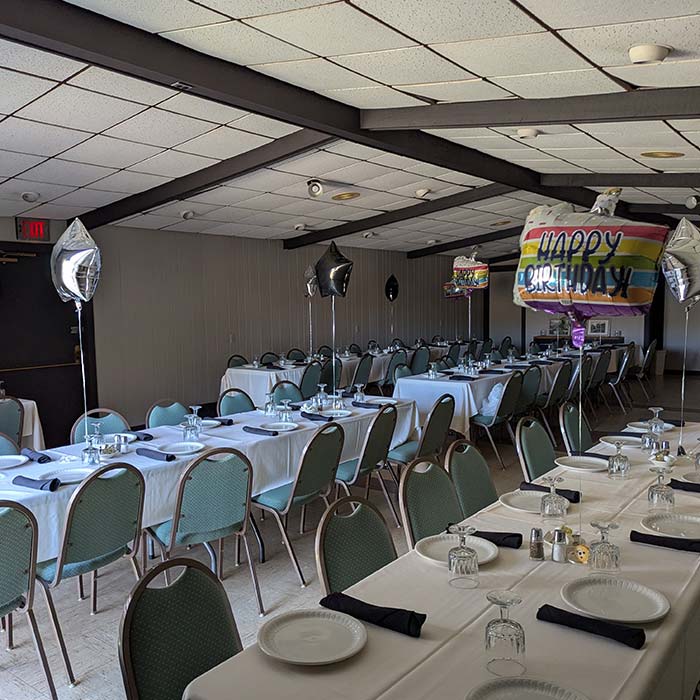 Birthday party setup at Marinette Restaurant with long tables, balloons, and festive decor.