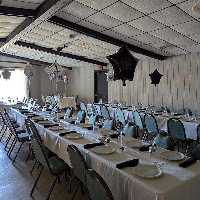 Long tables set for a party at Marinette Restaurant, sunlight pouring through the window.