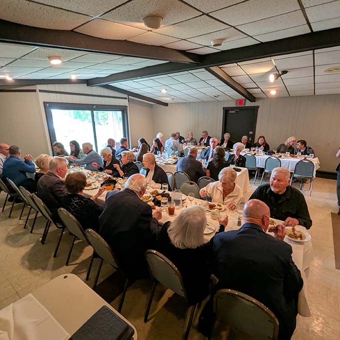 People gathered indoors, dining and conversing at Marinette Restaurant’s formal event.