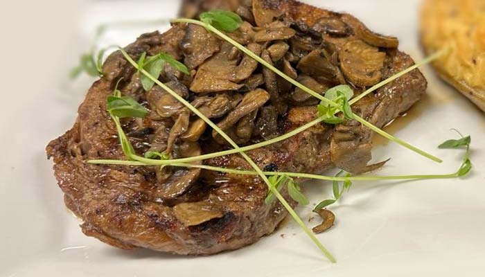 Grilled steak topped with sautéed mushrooms, served at River’s Edge Supper Club in Marinette.